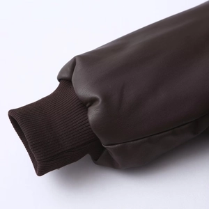 Close-up of deep brown faux leather sleeve with rib-knit cuffs and fine stitching detail