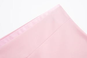 Détail du tissu satiné rose avec tissage élastique haute densité et coutures à double aiguille