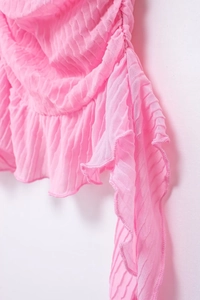 Dettaglio ravvicinato del tessuto a pieghe rosa vivace con volant e texture arricciata