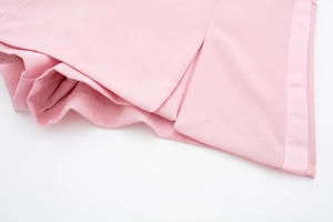 Détail de la texture satinée rose avec des finitions de couture précises et soignées
