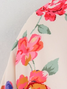 Detailansicht der lebendigen Blumendrucke auf weichem beige Textilgewebe im Makrostil