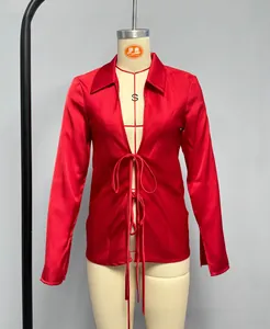 Detail of red satin blouse showing silk texture, notch lapel and front bow ties