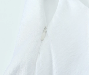 Close-up of the high-quality white satin fabric with invisible zipper and teardrop slider