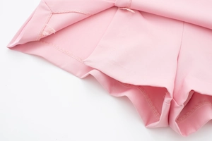 Détail du tissu satiné rose avec coutures professionnelles et finition de doublure