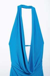 Detailed view of bright blue ribbed knit halter dress featuring deep V-neck and tie detail