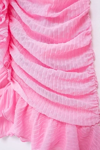 Dettaglio del tessuto rosa a strati con pieghe e texture verticale della vestaglia