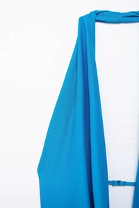 Detail of blue halter neck dress featuring textured fabric and metal back clasp closure