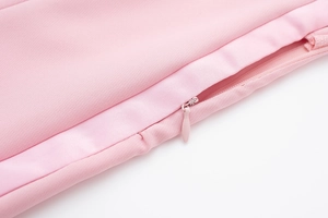 Détail du tissu satiné rose avec fermeture éclair invisible et coutures de précision