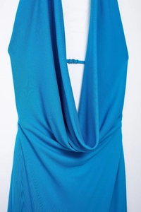 Detail of bright blue halter dress featuring a deep V-neck and elegant cowl neck draping