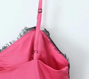 Détail d'une robe en satin rose avec dentelle noire et bretelles réglables