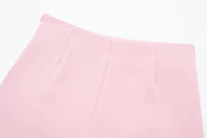 Détail du short en satin rose avec fermeture éclair invisible et plis à la taille