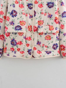 Detail einer gesteppten Jacke mit Vintage-Blumenmuster und Klappentaschen