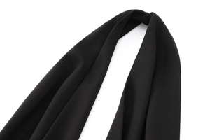 Dettaglio della trama del tessuto crepe nero di alta qualità e del drappeggio della tuta
