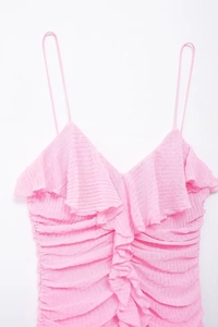 Dettaglio della trama a pieghe e delle balze sovrapposte sullo scollo dell'abito rosa