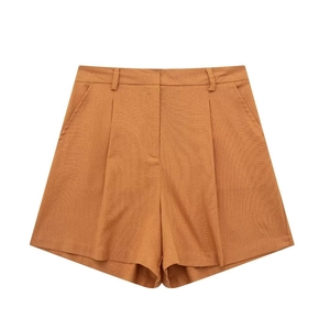 Detail view of high-waist linen shorts in caramel with pleats and side pockets