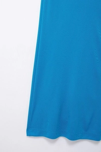 Detailed close-up of the electric blue dress hemline showing professional stitching and knit