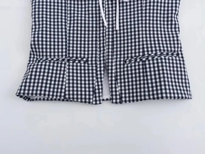 Detail of black and white gingham corset top featuring lace-up front and decorative pockets