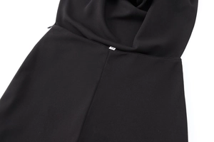 Dettaglio del tessuto crepe nero con cerniera invisibile ed etichetta della taglia XS