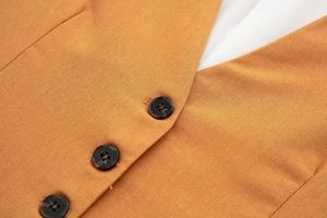 Detail of orange linen vest showing marble pattern buttons and textured fabric finish