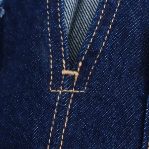 Detail von dunkelblauem Denim mit gelben Kontrastnähten und Twill-Stoffstruktur