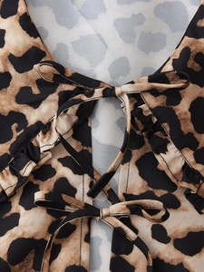 Detail of leopard print shirt featuring double bow ties and ruffle V-neckline accents