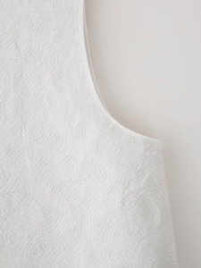 Gros plan détaillé du gilet rembourré blanc avec broderie matelassée en spirale élégante