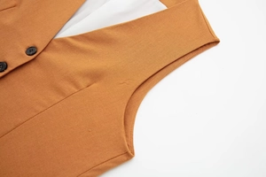 Detail of yellow linen vest with black buttons, V-neckline and high-quality stitching