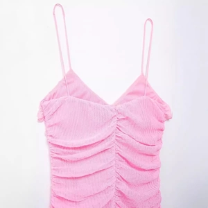 Abito estivo rosa da donna con spalline sottili ed eleganti pieghe a strati