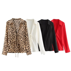 Detail of satin blouses with bow ties and button-down collars in four solid colors