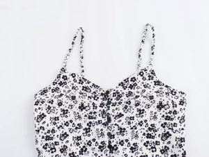 Close-up of floral sundress featuring thin straps, V-neckline and decorative front buttons
