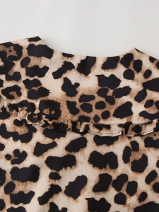 Close-up of leopard print fabric featuring a large ruffled collar with detailed stitching