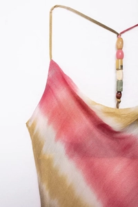 Dettaglio di abito tie-dye con scollo a cappuccio e spalline con perline multicolore