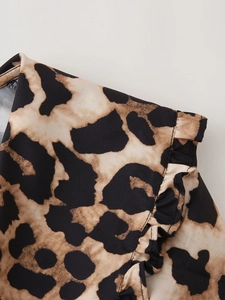 Macro shot of leopard print fabric texture and ruffled seam detail on the long sleeve shirt