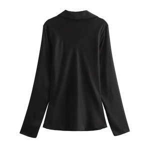 Detail view of the back of a smooth black satin long sleeve shirt with a glossy finish