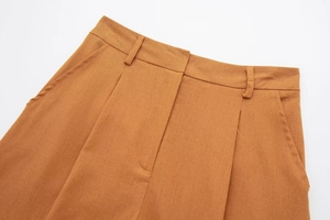 Close-up of caramel linen blend high waist trousers showing pleated waist and belt loops