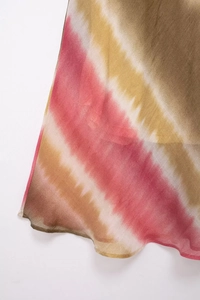 Dettaglio del tessuto tie-dye leggero con sfumatura rosa e gialla e orlo ondulato