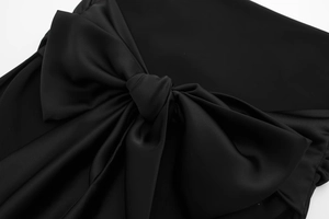 Close-up of elegant black satin fabric featuring a large decorative bow detail