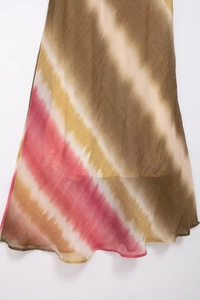 Dettaglio dell'abito midi tie-dye con motivi diagonali marroni e rosa e bordo ondulato