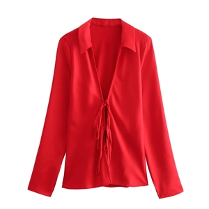 Detailed view of red satin shirt featuring front bow tie closure and classic collar