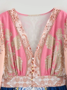 Dettaglio dello scollo a V profondo con bottoni decorativi su un abito a fiori paisley