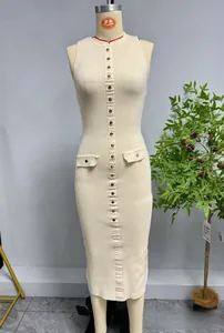 Detail der Rippstrick-Textur und elegante Goldknöpfe an einem schmalen cremefarbenen Kleid
