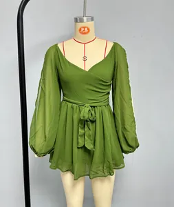 Detail of green V-neck chiffon dress showing waist tie and puff sleeve cuffs on mannequin