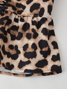 Detailed view of leopard print fabric with pleated ruffle edge and fine stitching