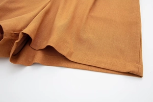 Close-up of caramel linen blend fabric showing natural texture and neat stitching