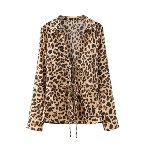Detail of leopard print satin shirt with V-neckline and delicate front bow tie closures