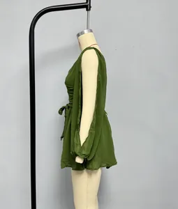 Detail of light green chiffon dress with cold-shoulder slit sleeves and tie-waist