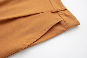 Detail of linen blend pants showing side pocket construction and stitching in ginger