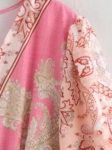 Dettaglio del tessuto paisley rosa con bordo a V e delicate pieghe sulla spalla