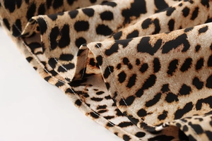 Detailed macro view of leopard print woven fabric with high-quality stitched edges