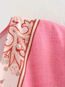 Dettaglio ravvicinato della stampa floreale paisley rosa sul vestito estivo con cuciture fini